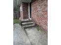 Exterior brick wall with concrete steps leading to a white door and weathered concrete in need of repair at 233 N Pandora Dr, Goose Creek, SC 29445