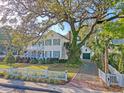 Beautiful home with a lush green lawn, mature trees, and a charming white picket fence at 304 Bank St, Mount Pleasant, SC 29464