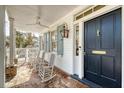 Relaxing front porch with rocking chairs, brick flooring, and a classic lantern fixture at 304 Bank St, Mount Pleasant, SC 29464