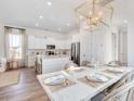 Open dining area featuring a modern light fixture, stainless steel appliances, and kitchen island seating at 309 Archar St, Summerville, SC 29486