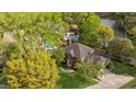 Aerial view showcasing a brick home, sparkling pool, mature trees, and a serene lake at 3176 Hagerty Dr, Charleston, SC 29414