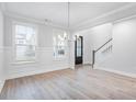 Bright dining room with modern lighting, large windows, and beautiful wood floors at 355 Wappoo Trace Ln, Summerville, SC 29486