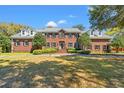 Classic red brick home featuring symmetrical design, mature trees, and a well-manicured lawn, perfect for curb appeal at 4029 Gift Blvd, Johns Island, SC 29455