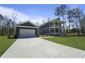 New construction home with blue siding, white trim, large driveway, garage and spacious manicured lawn at 4235 Royal Harbor Rd, Hollywood, SC 29449