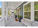 Inviting covered front porch with seating, stylish decor and large windows providing ample natural light at 4235 Royal Harbor Rd, Hollywood, SC 29449