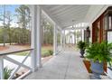Covered porch with brick floor, lantern lighting, and view of the grounds at 4310 Stonehouse Cir, Awendaw, SC 29429