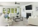 Bright living room featuring a fireplace, modern decor, neutral tones, and large windows offering a scenic view at 5104 Coneflower Ct, Johns Island, SC 29455