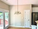 Bright dining area with hardwood floors, chandelier, and door leading to the backyard at 5182 Forest Oaks Dr, Hollywood, SC 29449