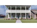 Charming two-story home with double porches, ceiling fans, rocking chairs and a landscaped front yard at 721 Blueway Ave, Summerville, SC 29486