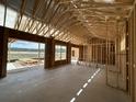 Unfinished interior of a home showing exposed studs, large windows, and a smooth concrete floor at 721 Blueway Ave, Summerville, SC 29486