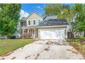 Charming two-story home with light green siding, a well-manicured lawn, and an attached two-car garage at 8499 Falling Leaf Ln, North Charleston, SC 29420