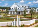 Beautiful two-story farmhouse exterior featuring modern design, well-kept landscaping, and charming white fence at 1014 Marsh Harrier Dr # Cc3-1-5, Ravenel, SC 29470