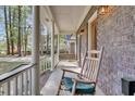 Relaxing front porch showcasing rocking chairs, a swing, brick accents, and elegant column supports at 109 Dan Miler Ln, Summerville, SC 29483