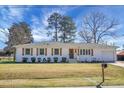 Charming painted-brick home featuring a lush lawn and tasteful wood shutters on a sunny day at 1113 Smithfield Pl, Hanahan, SC 29410
