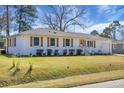 Beautiful painted-brick home showcases a manicured lawn and neat landscaping under a clear blue sky at 1113 Smithfield Pl, Hanahan, SC 29410