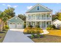 Charming two-story home with a front porch, a detached garage, and beautiful landscaping at 1213 Captain Rivers Dr, Charleston, SC 29412