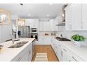 Modern white kitchen with stainless steel appliances, white countertops, and hardwood floors at 1213 Captain Rivers Dr, Charleston, SC 29412