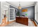 Elegant office with a large wooden desk, a patterned rug, a decorative light fixture, and a view of the hallway at 135 Marshside Dr, Summerville, SC 29485