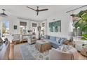 Bright and airy living room with a blue sofa, white chairs, and a ceiling fan at 1466 Mizzen Aly, Johns Island, SC 29455