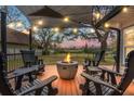 Inviting outdoor deck featuring a cozy fire pit surrounded by comfortable seating and a shaded awning at 1673 Mcclain St, Charleston, SC 29407