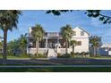 Charming home exterior featuring a welcoming porch, lush palm trees, and well-maintained lawn at 1715 Middle St, Sullivans Island, SC 29482