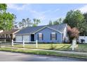 Lovely blue one-story home with a two-car garage, white picket fence, and lush landscaping at 188 Ponderosa Dr, Ladson, SC 29456