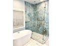 Modern bathroom with luxurious walk-in shower featuring marble tile, glass enclosure, and a freestanding bathtub by the window at 2000 Gray Battery Court Ct, Mount Pleasant, SC 29464