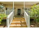 Charming front porch with white railings, flower pots, and a decorative front door at 213 Travelers Rest Blvd, Summerville, SC 29485