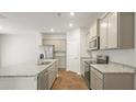Bright kitchen with stainless steel appliances, granite counters, island with sink, and wooden floors at 2152 Macallan Blvd, Ravenel, SC 29470