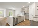 Open kitchen layout featuring a central island, stainless steel dishwasher, and hardwood flooring at 2152 Macallan Blvd, Ravenel, SC 29470