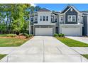 Townhome exterior features a long driveway, two-car garage, neutral colors, manicured lawn, and professionally landscaped shrubs at 3010 Emma Ln, Mount Pleasant, SC 29466