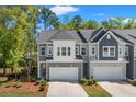 Two-story gray and white townhome showcasing garage, large driveway, landscaped front yard and healthy green lawn at 3010 Emma Ln, Mount Pleasant, SC 29466