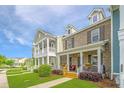 Charming two-story townhomes with inviting front porches and well manicured lawns under a blue sky at 3466 Yarmouth Dr, Mount Pleasant, SC 29466