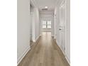 Bright hallway featuring neutral walls, white trim, and warm wood-look flooring at 347 Wappoo Trace Ln, Summerville, SC 29486