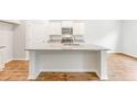 Bright, open kitchen with white cabinets, stainless steel appliances, and a large island with granite countertops at 348 Dickerson Ln, Lincolnville, SC 29485