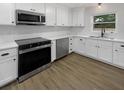 Modern kitchen with white cabinets, stainless steel appliances, a subway tile backsplash, and hardwood floors at 4412 Abby Dr, North Charleston, SC 29418