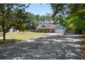 Charming single-story home with a long driveway surrounded by lush trees and ample parking space at 4429 Highway 162, Hollywood, SC 29449