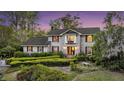 Charming two-story traditional home featuring a lush landscaped front yard with mature trees and manicured hedges at 506 Fairington Dr, Summerville, SC 29485