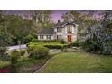 Charming two-story traditional home featuring a lush landscaped front yard with mature trees and manicured hedges at 506 Fairington Dr, Summerville, SC 29485