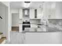 Modern kitchen featuring granite countertops, new stainless steel appliances, and gray backsplash at 509 Hill St, Moncks Corner, SC 29461