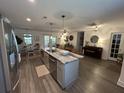 Spacious kitchen with large island featuring a stainless steel refrigerator, and adjacent dining and living areas at 640 Semaht St, Charleston, SC 29412