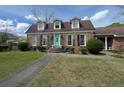 Inviting brick home with dormer windows, black shutters, and a vibrant teal front door at 805 Horne St, Saint George, SC 29477