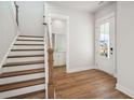 Entryway with wood floors leading to staircase, half bath and front door at 96 French Garden Cir, Summerville, SC 29486