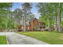 Classic brick home with inviting front porch, mature trees, and a long driveway on a well-manicured lawn at 104 Leighton Ct, Summerville, SC 29485