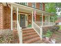 Inviting front porch with brick stairs, white railings, decorative wreath, and American flag waving proudly at 104 Leighton Ct, Summerville, SC 29485