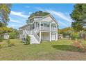 Raised beach house with white accents, garage parking, and greenery highlighting its inviting and functional design at 1224 Midvale Ave, Charleston, SC 29412
