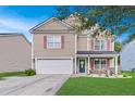 Inviting two-story home boasting a well-manicured lawn, attached garage, and a quaint front porch with seating at 1252 Wild Goose Trl, Summerville, SC 29483
