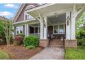 Close-up of the front porch featuring classic columns, decorative lighting, and a charming entrance at 126 Balfour Dr, Charleston, SC 29492