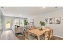 Bright dining area with a wood table, seamlessly connected to the living room and a door to the yard at 132 Haventree Ct, Summerville, SC 29486