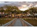 Scenic backyard view from the dock, showcasing the home's lights, expansive lawn, and mature trees at sunset at 1954 Sandy Point Ln, Mount Pleasant, SC 29466
